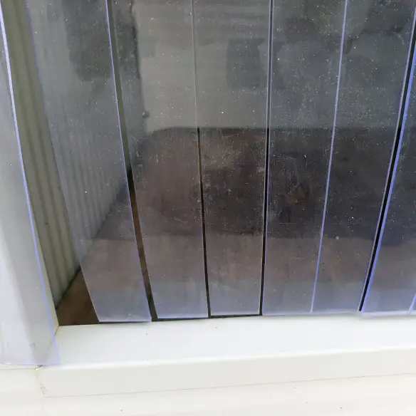 Detalle de cortina de tiras de PVC para casa de perro